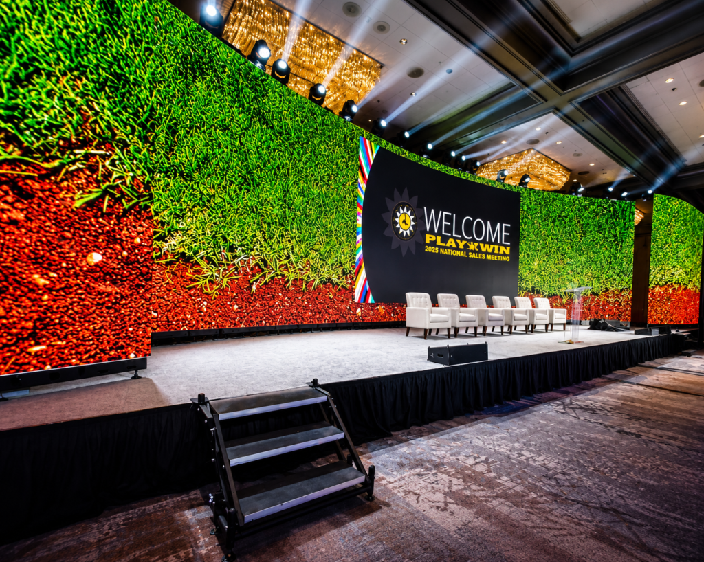 Large LED screen conference stage setup with professional lighting, staging, and audio visual production equipment at a corporate event in London.