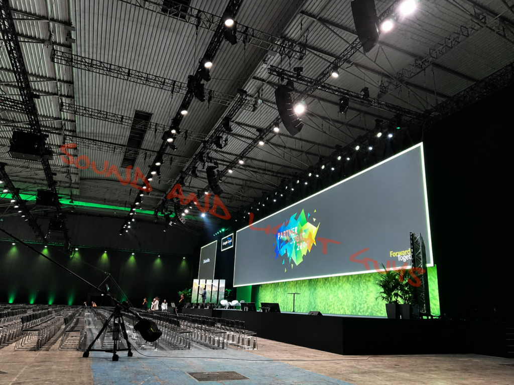 Large conference audio visual setup with LED stage screen and professional lighting